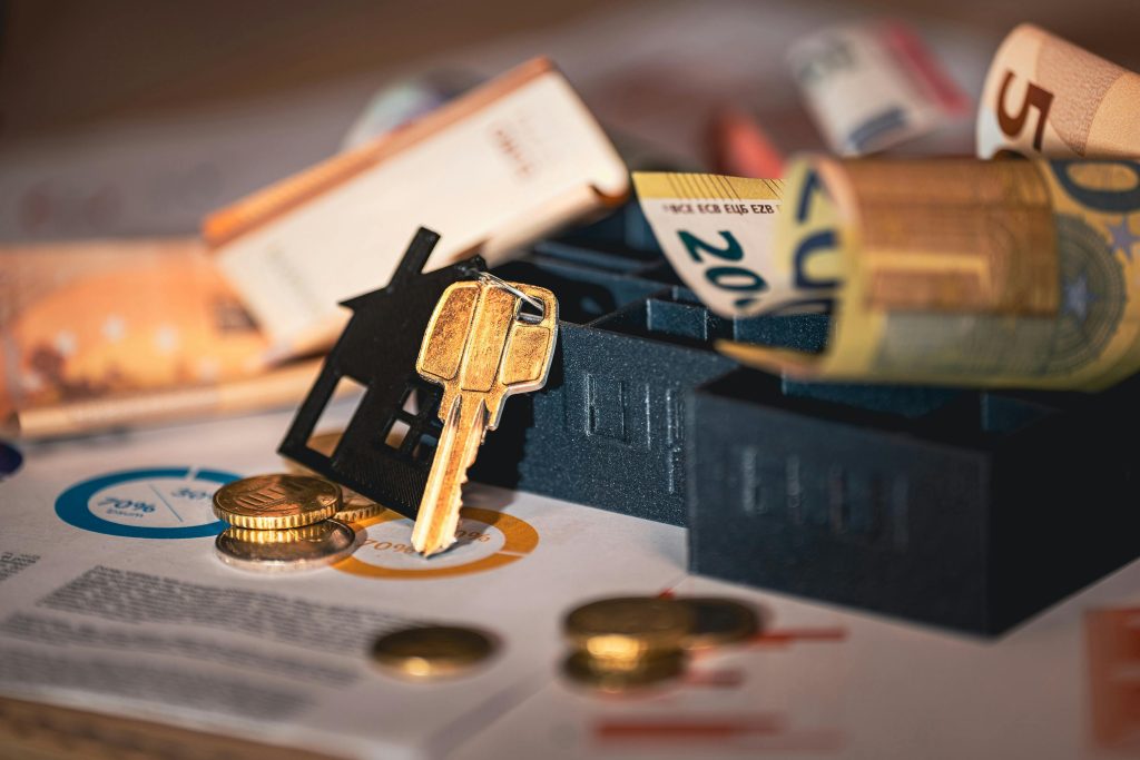 Combien coûte une visite virtuelle immobilière en Suisse ? Tarifs 2026 Close-up of house keys, euro bills, and charts symbolizing real estate investment and finance.